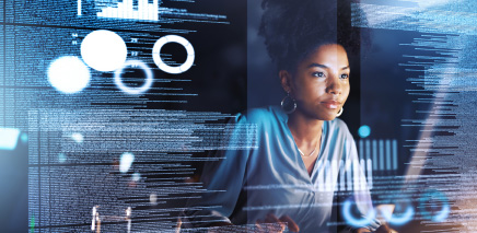 woman of color looking ate computer with charts and graphi