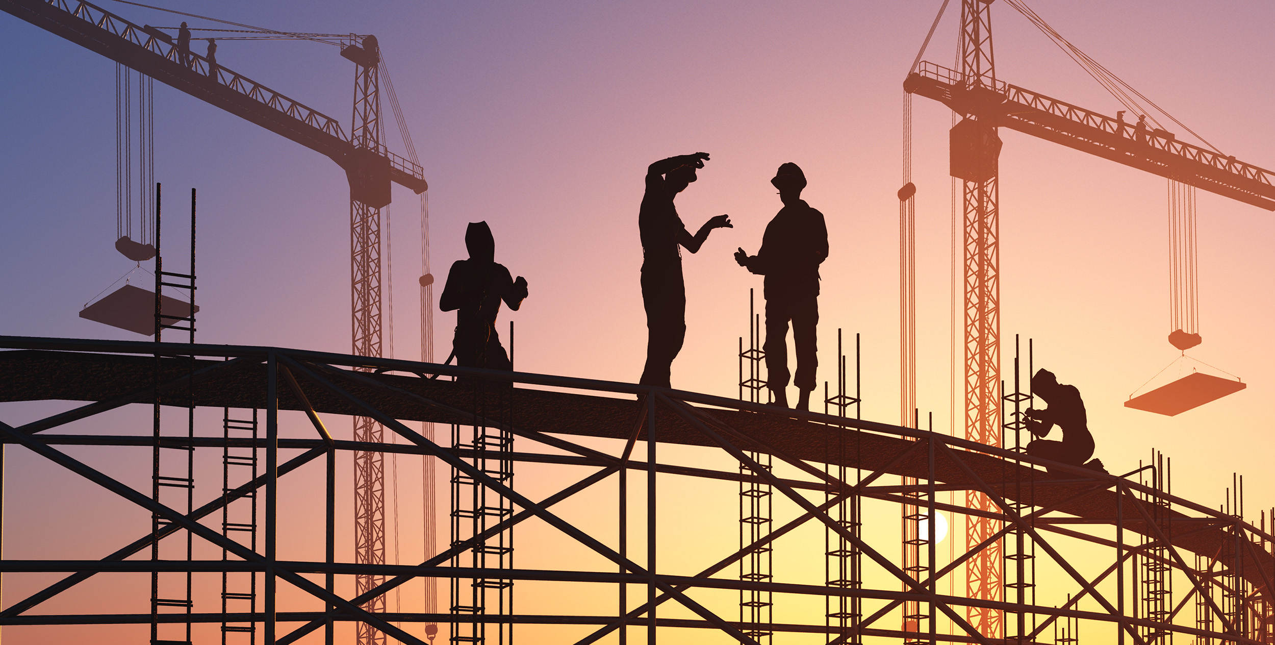Construction engineers working a top of rafters at dusk. Construction cranes in the background. 